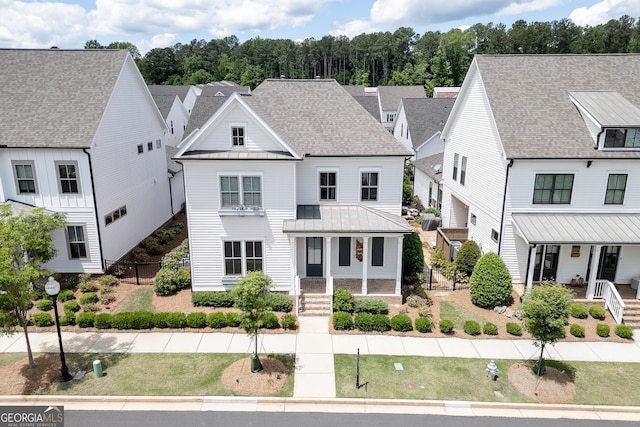 1023 Harvest Park Ln, Suwanee, GA 30024 - view of front facade with a standing seam roof, covered porch, metal roof, and fence