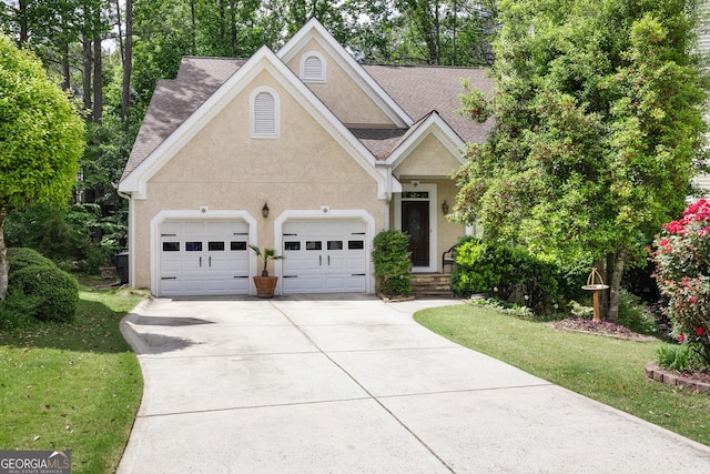 view of front facade featuring stucco siding, driveway, an attached garage, and a front lawn