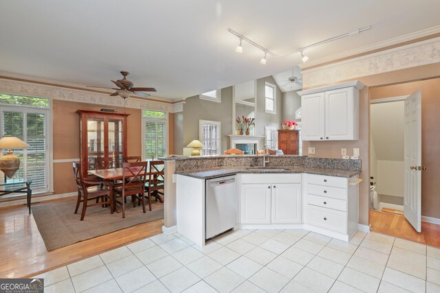 kitchen with a ceiling fan, stainless steel dishwasher, a sink, a peninsula, and ornamental molding