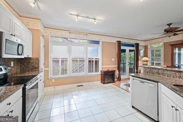 kitchen with stainless steel appliances, rail lighting, ceiling fan, white cabinetry, and french doors