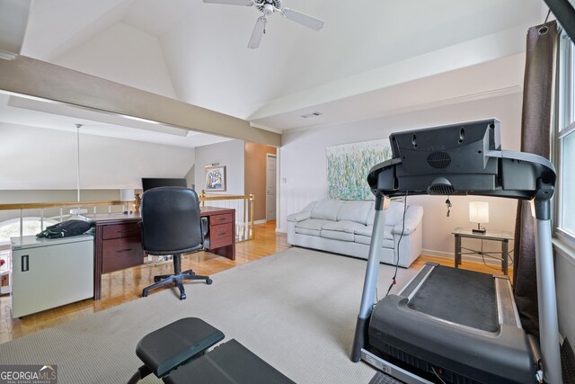 exercise room with wood finished floors, lofted ceiling, ceiling fan, and baseboards