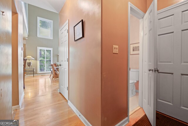 hall featuring light wood finished floors and baseboards