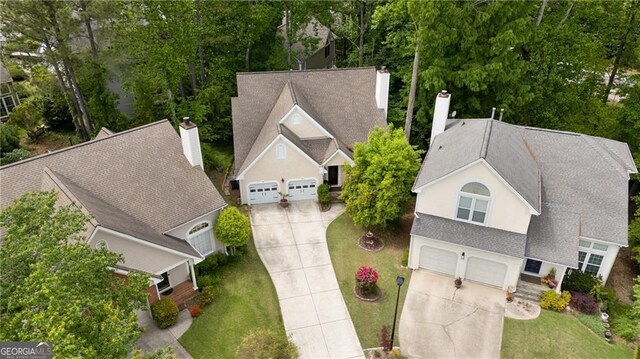 aerial view of property and surrounding area featuring a tree filled landscape