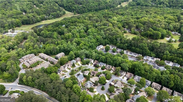 view of property location featuring a forest and nearby suburban area