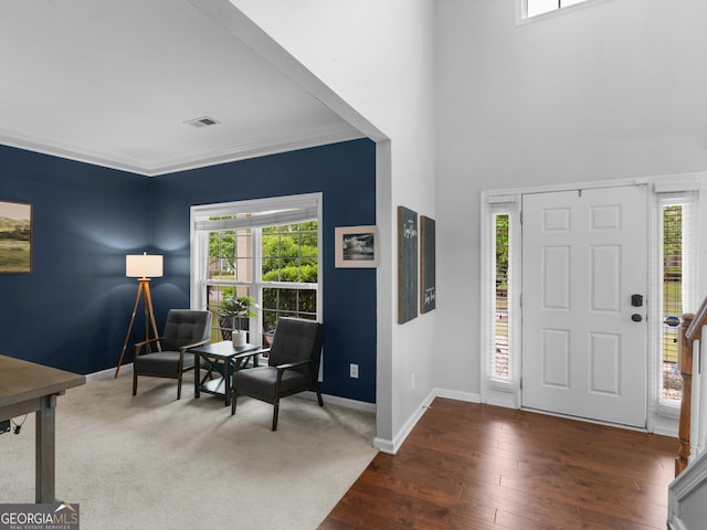 foyer entrance with baseboards, hardwood / wood-style floors, and crown molding