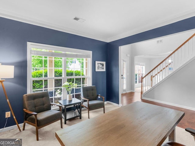 living room featuring stairs, baseboards, and crown molding