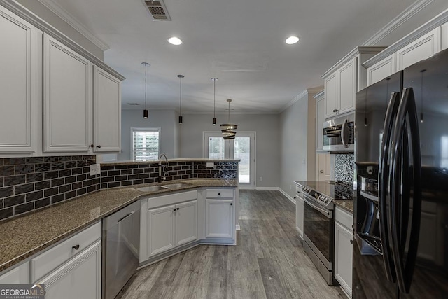 9565 Rushmore Cir, Braselton, GA 30517 - kitchen with appliances with stainless steel finishes, a sink, a peninsula, crown molding, and backsplash