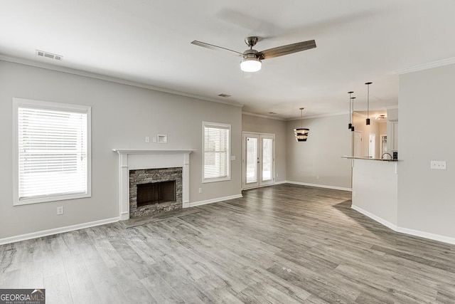 9565 Rushmore Cir, Braselton, GA 30517 - unfurnished living room with ceiling fan, wood finished floors, crown molding, baseboards, and a stone fireplace