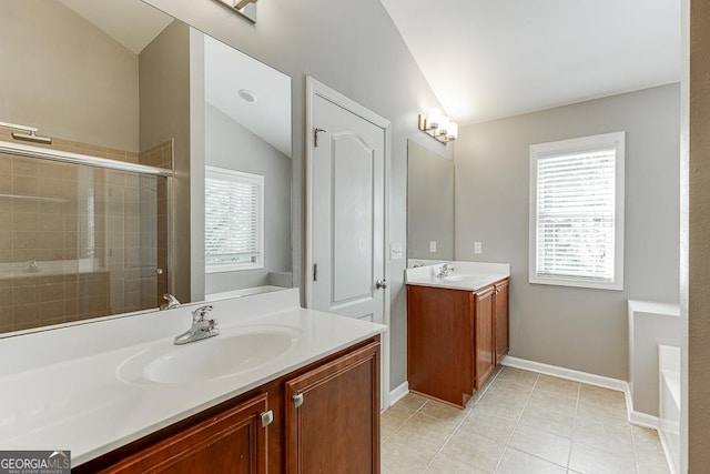 9565 Rushmore Cir, Braselton, GA 30517 - bathroom with vaulted ceiling, tiled shower, two vanities, tile patterned flooring, and baseboards
