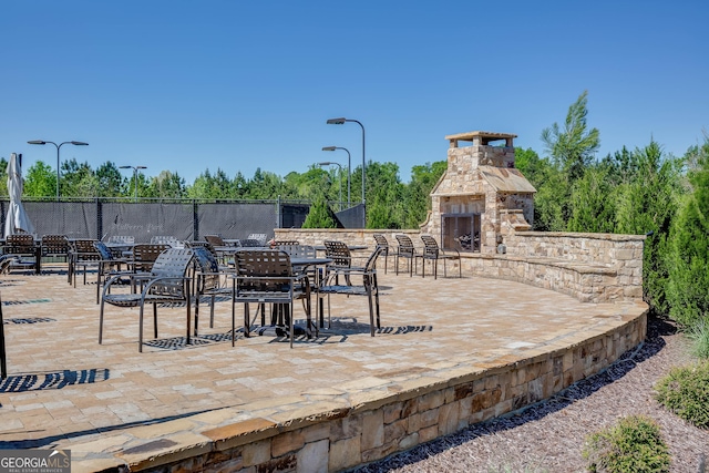 9565 Rushmore Cir, Braselton, GA 30517 - view of patio with an outdoor stone fireplace and fence
