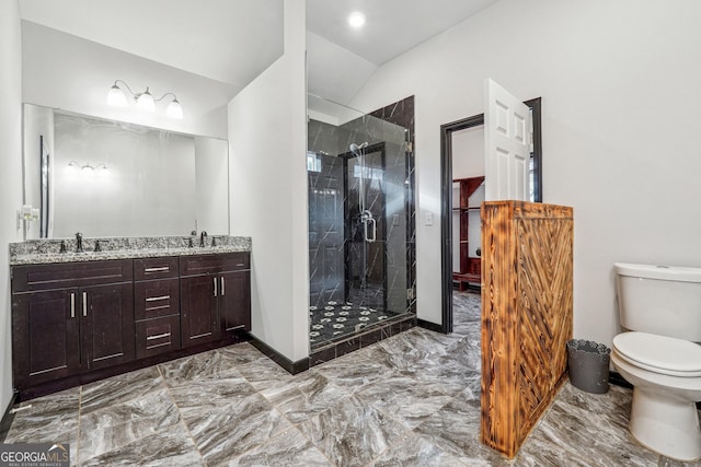 bathroom featuring lofted ceiling, toilet, a stall shower, double vanity, and marble finish flooring