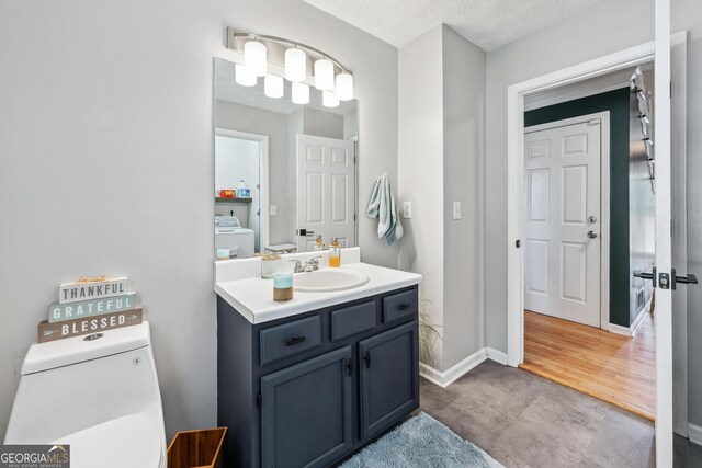 2349 June Springs Dr SW, Marietta, GA 30008 - half bath featuring washer / dryer, vanity, toilet, and baseboards