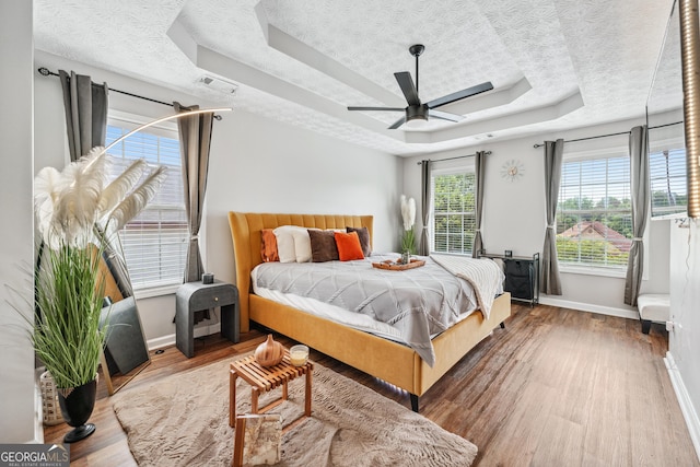 2349 June Springs Dr SW, Marietta, GA 30008 - bedroom with a tray ceiling, wood finished floors, baseboards, and ceiling fan