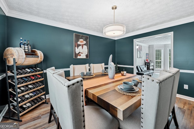 2349 June Springs Dr SW, Marietta, GA 30008 - dining room with wood finished floors, a textured ceiling, ornamental molding, and baseboards