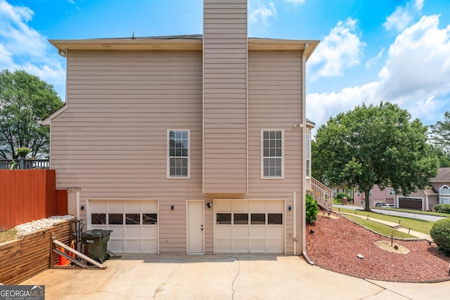 2349 June Springs Dr SW, Marietta, GA 30008 - view of home's exterior featuring a garage, driveway, and a chimney