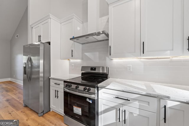 103 Spruce Ln, Eatonton, GA 31024 - kitchen with stainless steel appliances, wall chimney exhaust hood, white cabinets, light wood finished floors, and vaulted ceiling