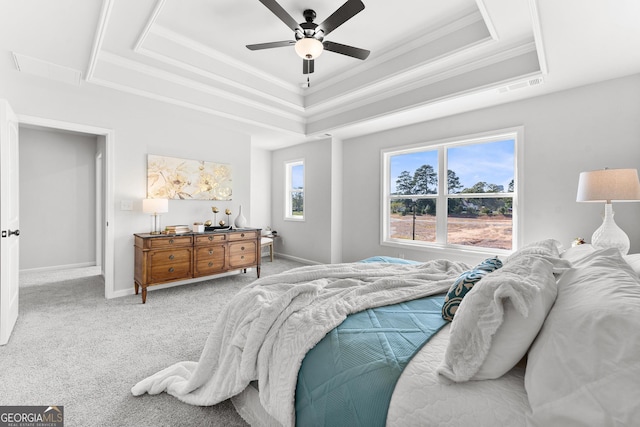 bedroom with a tray ceiling, ornamental molding, carpet, ceiling fan, and baseboards