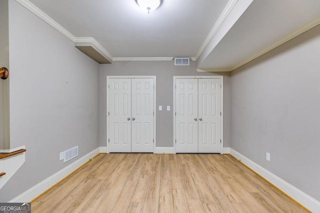 7511 Biltmore Ln, Douglasville, GA 30135 - unfurnished bedroom with multiple closets, light wood-type flooring, crown molding, and baseboards