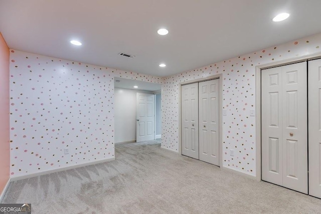 7511 Biltmore Ln, Douglasville, GA 30135 - unfurnished bedroom featuring multiple closets, light colored carpet, recessed lighting, wallpapered walls, and baseboards