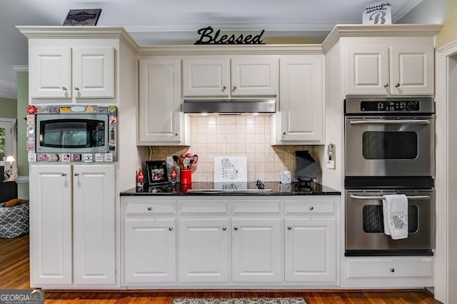 7511 Biltmore Ln, Douglasville, GA 30135 - kitchen featuring stainless steel appliances, under cabinet range hood, decorative backsplash, wood finished floors, and ornamental molding