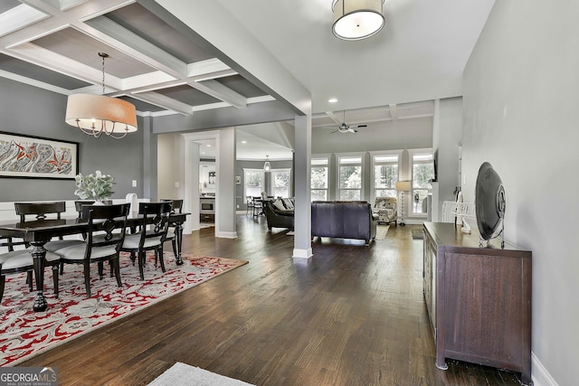 dining area featuring dark wood-style floors, a chandelier, beamed ceiling, a ceiling fan, and baseboards