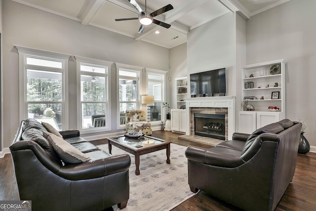living area with ceiling fan, coffered ceiling, crown molding, dark wood-style floors, and beam ceiling