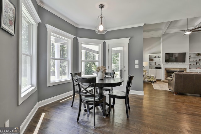 dining room featuring healthy amount of natural light, a fireplace, baseboards, crown molding, and beamed ceiling