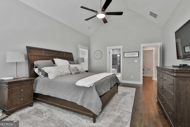 bedroom with high vaulted ceiling, wood finished floors, ensuite bathroom, baseboards, and a ceiling fan