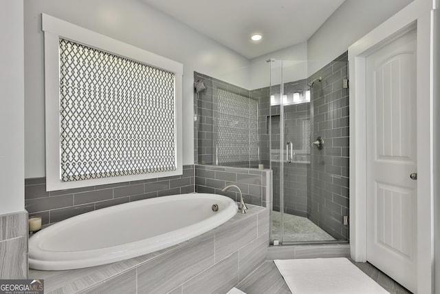 full bathroom with a bath and a shower stall