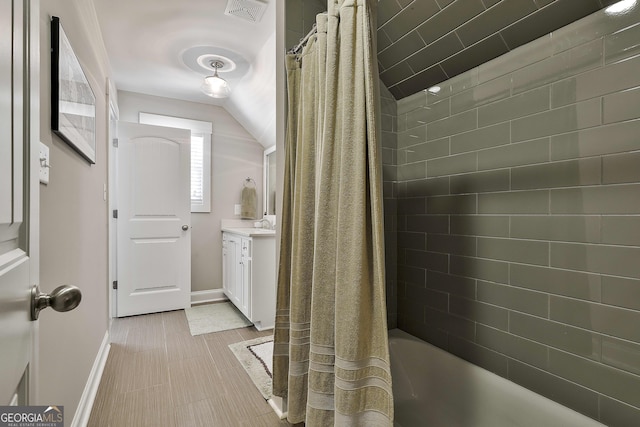 full bathroom with vaulted ceiling, vanity, baseboards, and shower / bath combination with curtain