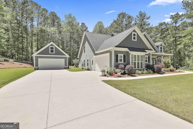 craftsman-style home with a front yard, a detached garage, covered porch, an outdoor structure, and driveway