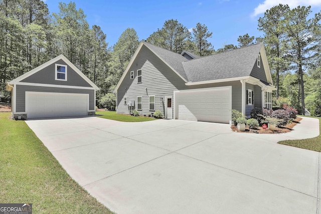 view of front facade with a shingled roof, a front lawn, and driveway