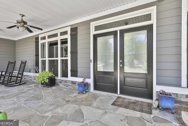 view of exterior entry featuring a ceiling fan and a porch