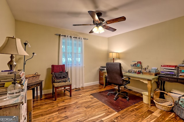 home office featuring light wood finished floors, ceiling fan, and baseboards