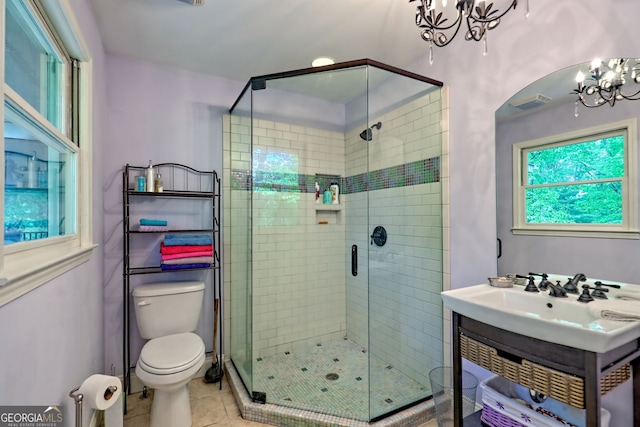 bathroom featuring a chandelier, a stall shower, toilet, and tile patterned floors