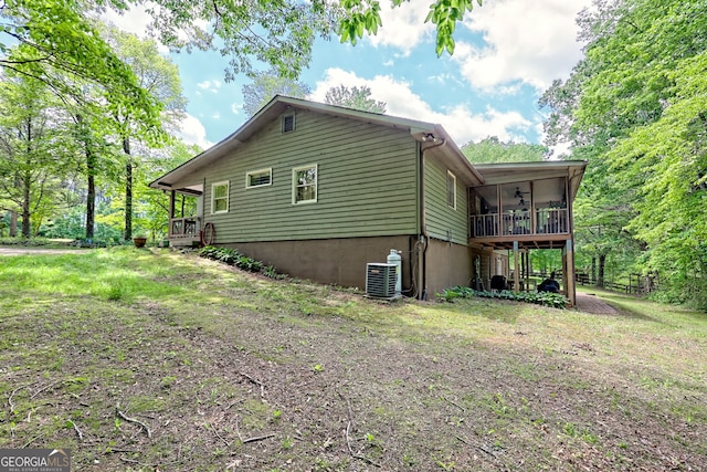 view of side of home with a ceiling fan, central AC, and a deck