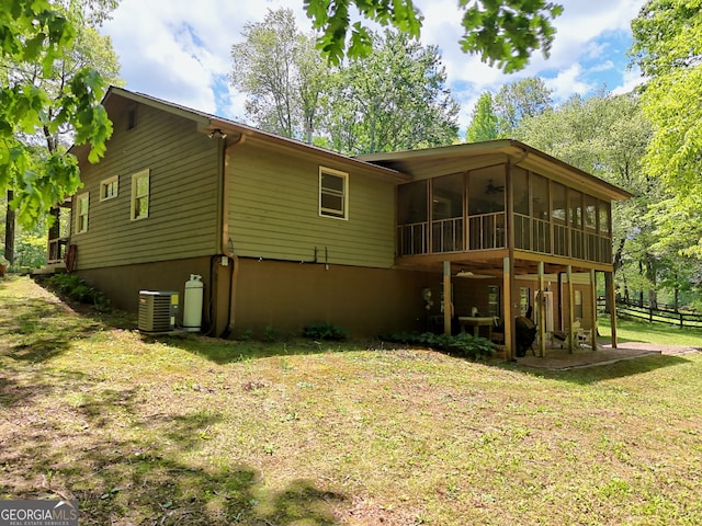 rear view of house with a sunroom, cooling unit, and a ceiling fan