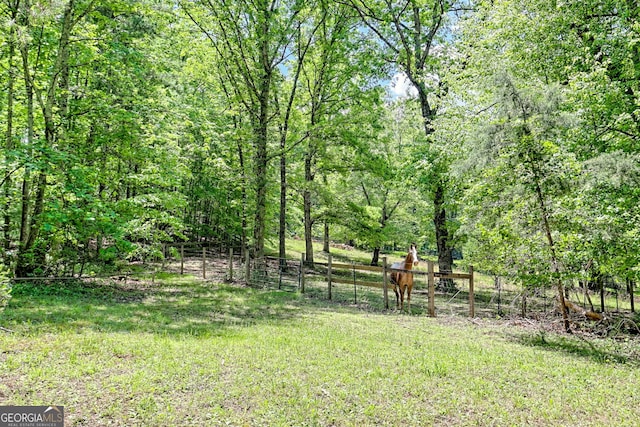 view of yard with fence and a view of trees