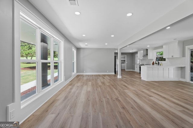 2604 Flat Shoals Rd SW, Conyers, GA 30094 - unfurnished living room with recessed lighting, light wood finished floors, baseboards, and a sink