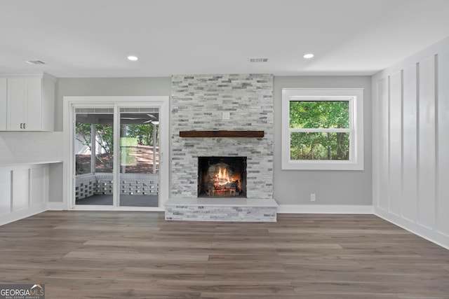 2604 Flat Shoals Rd SW, Conyers, GA 30094 - unfurnished living room featuring healthy amount of natural light, a stone fireplace, wood finished floors, and recessed lighting