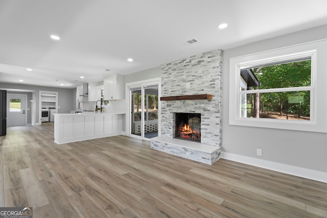 2604 Flat Shoals Rd SW, Conyers, GA 30094 - unfurnished living room with a fireplace, healthy amount of natural light, light wood-style floors, and recessed lighting