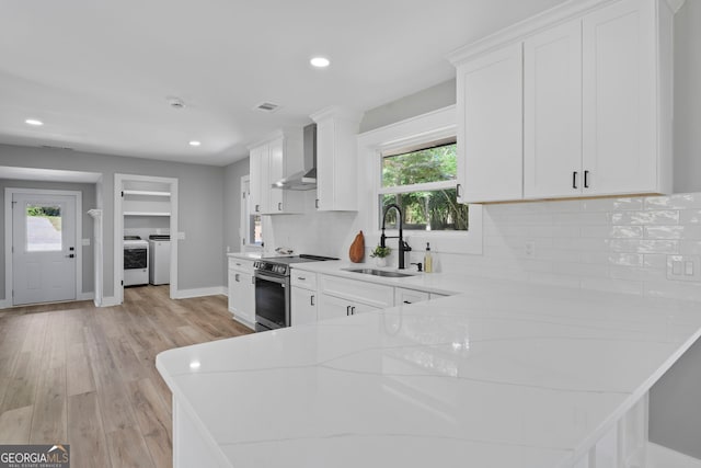 2604 Flat Shoals Rd SW, Conyers, GA 30094 - kitchen with a sink, separate washer and dryer, stainless steel electric stove, wall chimney exhaust hood, and light countertops