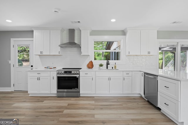 2604 Flat Shoals Rd SW, Conyers, GA 30094 - kitchen featuring appliances with stainless steel finishes, wall chimney exhaust hood, a sink, light countertops, and recessed lighting