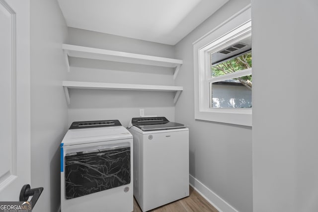 2604 Flat Shoals Rd SW, Conyers, GA 30094 - washroom with washing machine and dryer, light wood-style flooring, and baseboards