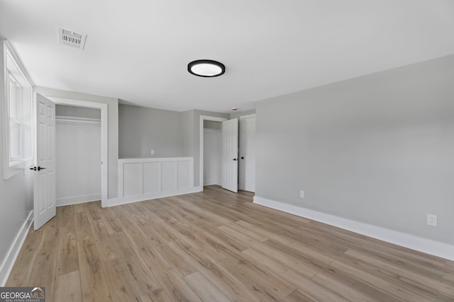 2604 Flat Shoals Rd SW, Conyers, GA 30094 - unfurnished bedroom with two closets, light wood-style floors, and baseboards