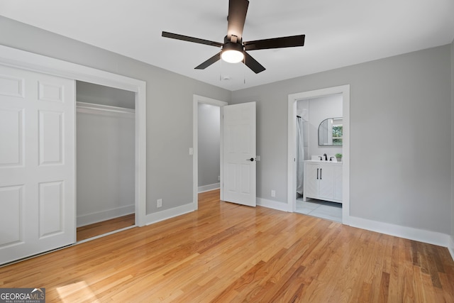 2604 Flat Shoals Rd SW, Conyers, GA 30094 - unfurnished bedroom with a closet, baseboards, light wood finished floors, ensuite bathroom, and ceiling fan