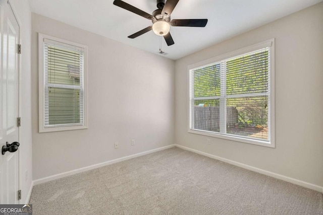 carpeted spare room with baseboards and ceiling fan
