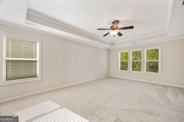 unfurnished room with a tray ceiling, ornamental molding, ceiling fan, carpet flooring, and baseboards