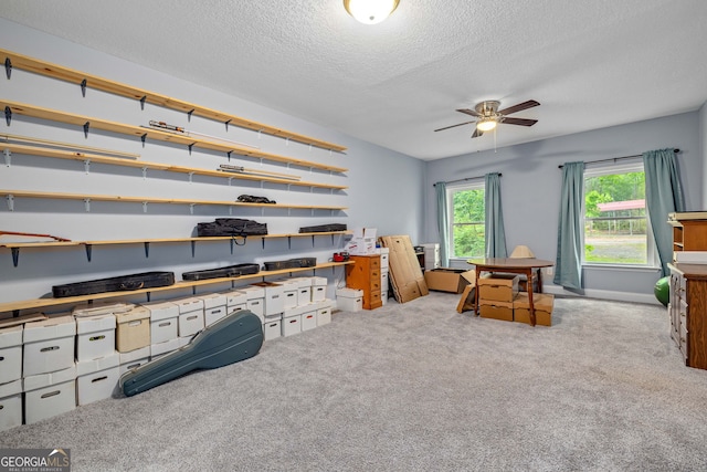 carpeted home office with a textured ceiling and a ceiling fan