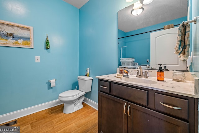 full bath featuring toilet, baseboards, wood finished floors, vanity, and a shower